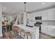 Eat-in kitchen offers island seating, stainless appliances, and seamless flow to the dining room and staircase at 648 W End Dr, Charlotte, NC 28208