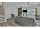 Cozy living room featuring gray sofa, modern wall decor, and stairs leading to the next level at 648 W End Dr, Charlotte, NC 28208