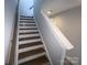 Staircase with hardwood treads, white risers, and gray walls leading to upper level at 648 W End Dr, Charlotte, NC 28208