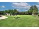 Expansive backyard featuring a well-manicured lawn, charming landscaping, and a cozy fire pit area at 7005 W Duncan Rd, Indian Trail, NC 28079