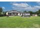 Large backyard with lush greenery, fire pit, and an outdoor shed, offering ample space for recreation and relaxation at 7005 W Duncan Rd, Indian Trail, NC 28079