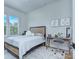 Cozy bedroom featuring a striped bedspread, a wooden desk, and bright natural lighting through large windows at 7005 W Duncan Rd, Indian Trail, NC 28079