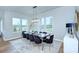 Open dining area with hardwood flooring features designer lighting, contemporary furniture, and large windows at 7005 W Duncan Rd, Indian Trail, NC 28079