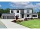 Beautiful two-story home with gray accents, modern design, well-manicured lawn, and an attached three-car garage at 7005 W Duncan Rd, Indian Trail, NC 28079