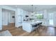 Bright kitchen with white cabinetry, marble countertops, stainless steel appliances, and modern pendant lighting at 7005 W Duncan Rd, Indian Trail, NC 28079