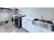 Well-equipped laundry room with a farmhouse sink, modern washer and dryer, and practical shelving for storage at 7005 W Duncan Rd, Indian Trail, NC 28079