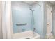 Full blue tiled bathroom with tub and shower featuring a grab bar for safety and convenience at 726 Grandview Ne Dr, Concord, NC 28025