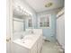 Bathroom with double sink vanity, large mirror, and blue tile shower and tub at 726 Grandview Ne Dr, Concord, NC 28025