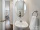 A half bathroom has a pedestal sink and an oval mirror at 7445 Abigail Glen Dr, Charlotte, NC 28212