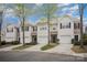 View of townhomes with garages and driveways, surrounded by mature trees and landscaping at 7445 Abigail Glen Dr, Charlotte, NC 28212