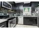 Well-lit kitchen features stainless steel appliances, stylish backsplash, and ample dark wood cabinets at 8301 Washington Blvd, Charlotte, NC 28262