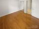 Spacious bedroom featuring hardwood floors, sliding closet doors, and neutral walls at 8929 Meadow Vista Rd, Charlotte, NC 28213