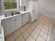 Bright kitchen featuring white cabinets, stainless steel sink, and a full-size refrigerator at 8929 Meadow Vista Rd, Charlotte, NC 28213
