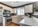 Kitchen features stainless steel appliances, white cabinets, gray walls, and ample counter space with a view of the outside at 9052 Meadowmont View Dr, Charlotte, NC 28269