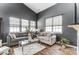 Bright living room featuring modern windows, a plush gray sofa, and a glass coffee table at 9052 Meadowmont View Dr, Charlotte, NC 28269
