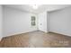 This bedroom includes neutral walls, modern flooring, a double door closet, and a window at 1034 Dooley Dr, Charlotte, NC 28227