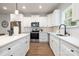 Contemporary kitchen with white cabinets, quartz countertops, stainless steel appliances and hardwood floors at 1034 Dooley Dr, Charlotte, NC 28227