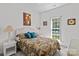 A cozy bedroom featuring wicker furniture, soft lighting, and large window views at 11841 Mourning Dove Ln, Charlotte, NC 28269