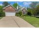 Charming brick home with a well-manicured lawn and a two-car garage with a concrete driveway at 11841 Mourning Dove Ln, Charlotte, NC 28269