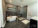 Modern bathroom with a soaking tub, glass-enclosed shower, and sleek black and gray tile work at 12069 Coyle Rd, Stanfield, NC 28163