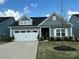 Charming single-Gathering home with a well-manicured lawn and a two-car garage, showcasing curb appeal under a bright sky at 123 Grey Fox Ln, Mount Gilead, NC 27306