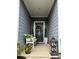 Inviting front porch features a decorative wreath, potted plants, and a cozy bench, creating a welcoming entrance at 123 Grey Fox Ln, Mount Gilead, NC 27306