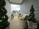Cozy front porch view with bench seating and potted topiaries, offering a glimpse of the neighborhood at 123 Grey Fox Ln, Mount Gilead, NC 27306