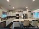 Bright, airy kitchen with white cabinetry, stainless steel appliances, and a large center island with seating at 123 Grey Fox Ln, Mount Gilead, NC 27306