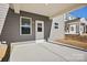 Covered back porch with a white door and gray siding, creating a welcoming outdoor space at 13737 Roderick Dr # 186, Huntersville, NC 28078