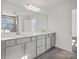 Modern bathroom featuring double sinks, a large mirror, and neutral finishes for a bright, spacious feel at 13737 Roderick Dr # 186, Huntersville, NC 28078