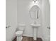 Bathroom with pedestal sink, oval mirror, and a classic white toilet at 13737 Roderick Dr # 186, Huntersville, NC 28078