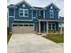 Two-story home showcases a blue exterior, a two-car garage and a well-manicured front lawn at 13737 Roderick Dr # 186, Huntersville, NC 28078