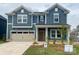Two-story home showcases a blue exterior, a two-car garage and a well-manicured front lawn at 13737 Roderick Dr # 186, Huntersville, NC 28078
