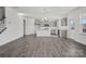 Open kitchen features stainless appliances, gray cabinets, an island, and gray laminate wood flooring at 13737 Roderick Dr # 186, Huntersville, NC 28078