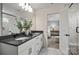 A bathroom with double sinks, a black countertop, and a view into the main bedroom at 13752 Roderick Dr # 175, Huntersville, NC 28078