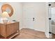 Charming entryway with wood-look floors, a modern cabinet with a round mirror, and a white front door with black hardware at 13752 Roderick Dr # 175, Huntersville, NC 28078