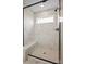 Modern walk-in shower with marble-look tiling, a glass enclosure, a bench, and a window at 13752 Roderick Dr # 175, Huntersville, NC 28078