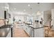 Open concept kitchen with stainless appliances, island seating, and views into the dining and living areas at 15019 Meadows Hunt Ln # 163, Huntersville, NC 28078