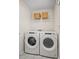 Functional laundry room equipped with a washer, dryer, storage shelf and tiled flooring for convenience at 15019 Meadows Hunt Ln # 163, Huntersville, NC 28078