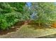 Fenced backyard with green grass, trees, and partial home view at 15035 Ockeechobee Ct, Mint Hill, NC 28227