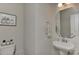 Cozy powder room with a pedestal sink, decorative mirror, and elegant fixtures at 15035 Ockeechobee Ct, Mint Hill, NC 28227
