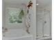 Bright bathroom featuring a soaking tub, glass-enclosed shower, and serene natural light at 15035 Ockeechobee Ct, Mint Hill, NC 28227