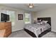 Comfortable bedroom with a ceiling fan, dresser, and large windows for ample natural light at 15035 Ockeechobee Ct, Mint Hill, NC 28227