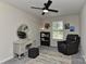 Carpeted bedroom with ceiling fan, vanity, and a comfortable chair near a sunlit window at 15035 Ockeechobee Ct, Mint Hill, NC 28227
