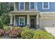 Inviting front porch with decorative columns, colorful flowers, and a cozy seating area for relaxing at 15035 Ockeechobee Ct, Mint Hill, NC 28227