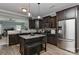 Open kitchen with stainless appliances, dark wood cabinets, granite countertops, and a convenient kitchen island at 15035 Ockeechobee Ct, Mint Hill, NC 28227
