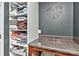 Bright laundry room featuring open shelving stocked with linens, countertop space, and neutral wall color at 15035 Ockeechobee Ct, Mint Hill, NC 28227