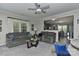 Inviting living room with plush gray seating, a ceiling fan, and an open view to the kitchen at 15035 Ockeechobee Ct, Mint Hill, NC 28227