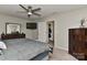 Relaxing main bedroom with a ceiling fan, dresser, and a glimpse into the ensuite bathroom at 15035 Ockeechobee Ct, Mint Hill, NC 28227