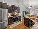 Stylish kitchen features stainless steel appliances, dark wood cabinets, and granite countertops at 1669 Beleek Ridge Ln, Clover, SC 29710
